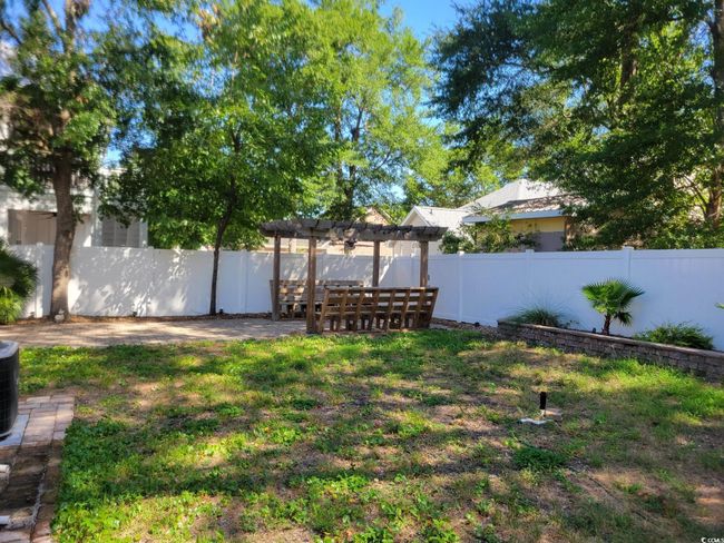 Fenced backyard with a pergola and a patio area | Image 21
