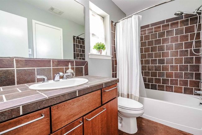 Bathroom featuring vanity, toilet, shower / tub combo, backsplash, and visible vents | Image 10