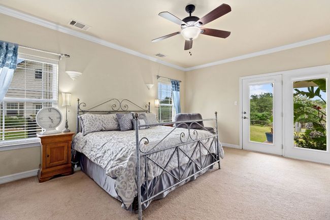 Spacious primary suite downstairs with door leading to the lush back yard. | Image 16