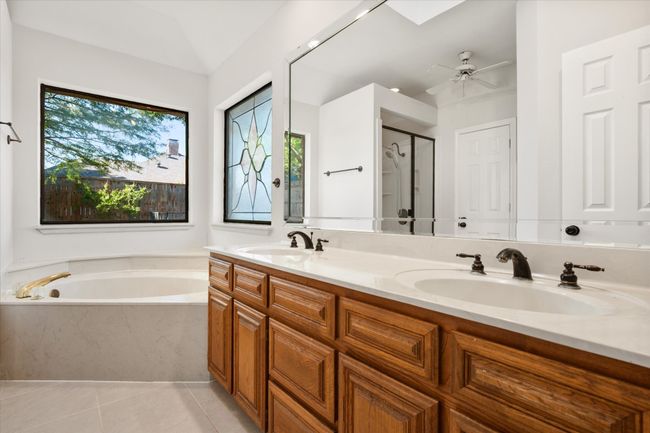 Dual sinks make getting ready a breeze. The beveled glass mirror is the full length of the vanity. Ceramic tile floors make cleaning easy. There are windows for natural light. | Image 33