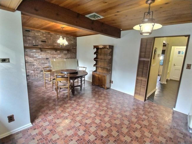 Doorway featuring radiator heating unit, baseboards, brick patterned flooring, and wood ceiling | Image 13