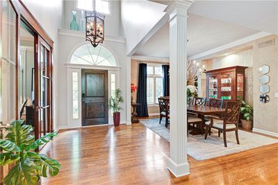 Entrance foyer featuring a wealth of natural light, an inviting chandelier, decorative columns, and light hardwood / wood-style floors | Image 3