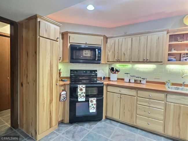 Sleek hickory cabinets span the wall of the kitchen offering plenty of storage space. The double oven will come in handy when creating special meals for the friends and family coming to enjoy your company and hang out at the lake! | Image 27