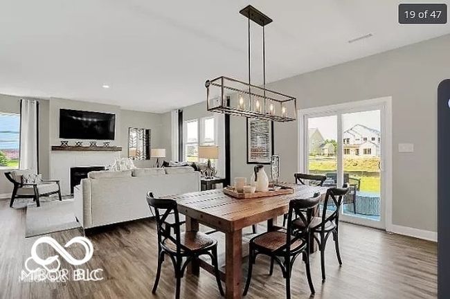 dining room with a notable chandelier, dark wood-style flooring, baseboards, and a healthy amount of sunlight | Image 7