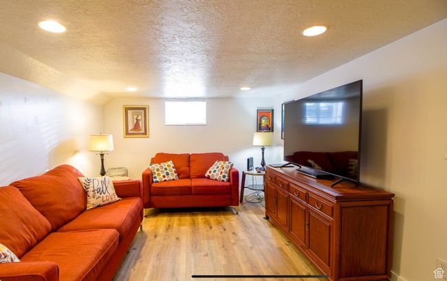 Living room featuring a textured ceiling, light wood-style flooring, and recessed lighting | Image 17