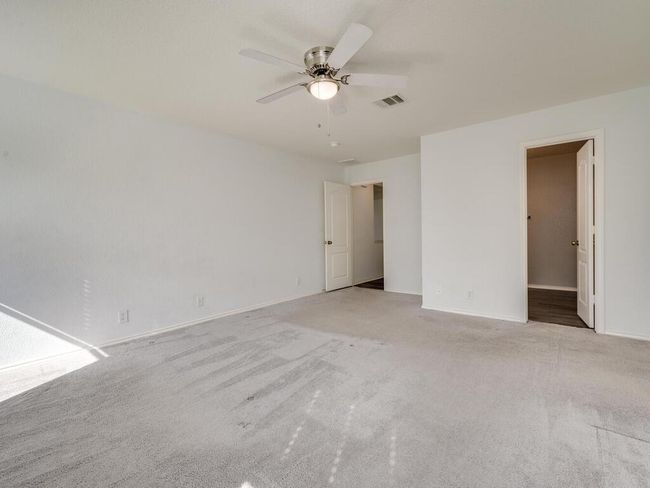 Primary bedroom featuring two closets, carpet floors, and a ceiling fan. | Image 17