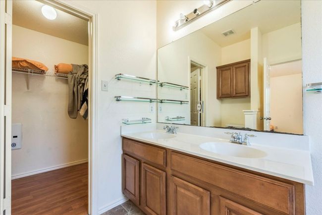 Full bath featuring toilet, double vanity, a spacious closet, and wood finished floors | Image 11