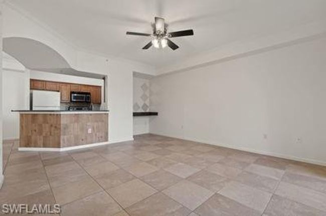 Unfurnished living room featuring light tile patterned floors, baseboards, and a ceiling fan | Image 10