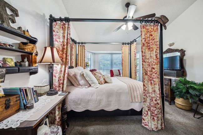 Carpeted bedroom with vaulted ceiling, ceiling fan, and a textured ceiling | Image 20