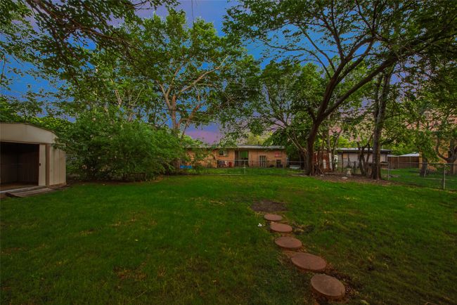 View of yard with fence, an outdoor structure, and a storage shed | Image 14