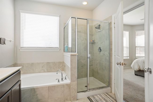 Ensuite bathroom featuring a bath, a stall shower, vanity, and recessed lighting | Image 11