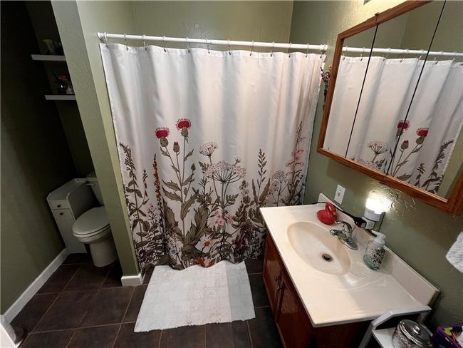 Full bath with vanity, a shower with curtain, and tile patterned floors | Image 14