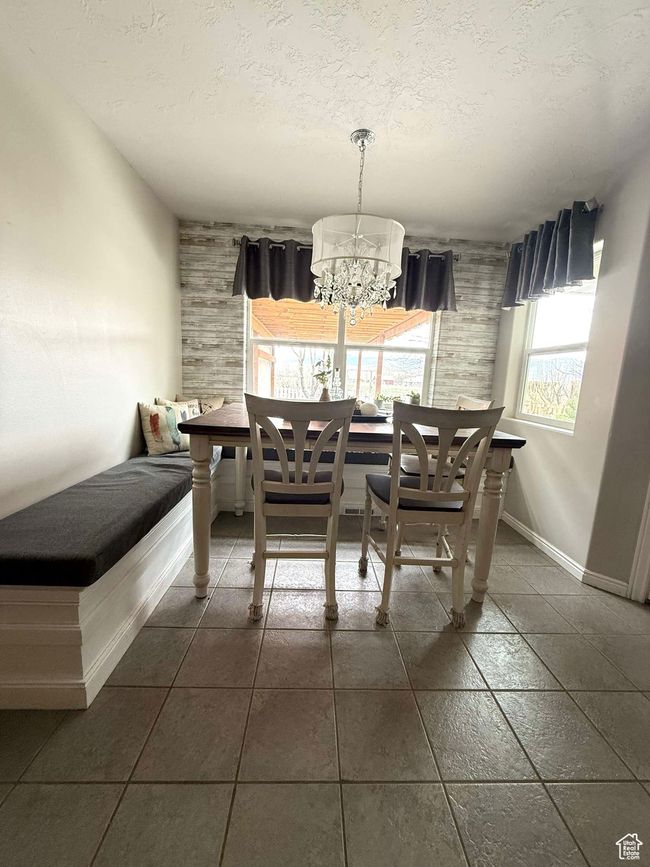 Dining area with a textured ceiling, a notable chandelier, and baseboards | Image 19