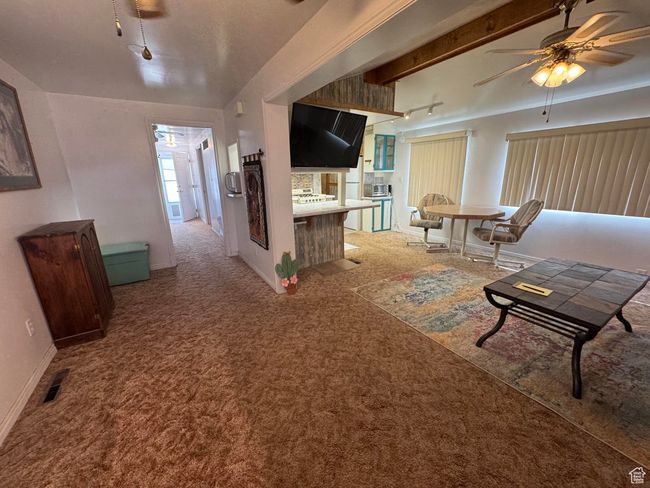 Carpeted living room featuring ceiling fan and baseboards | Image 7