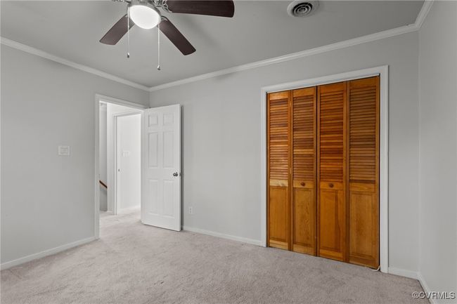 Unfurnished bedroom featuring carpet floors, crown molding, visible vents, and baseboards | Image 28