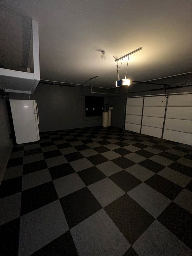 Garage with a garage door opener and fridge | Image 19