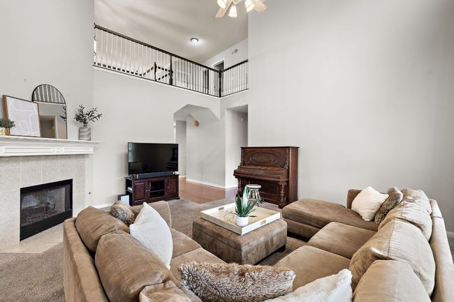 The living room is bright and open with fresh paint throughout, a gas fireplace, 2-story ceilings, and opens to the kitchen and breakfast nook. It also overlooks the beautiful backyard! | Image 16