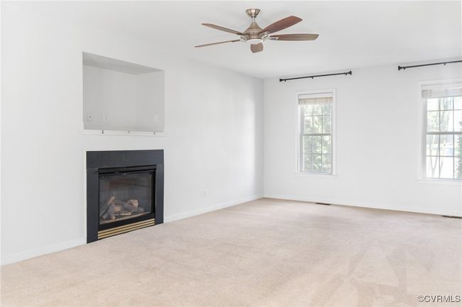 Unfurnished living room with ceiling fan, a glass covered fireplace, and carpet floors | Image 14