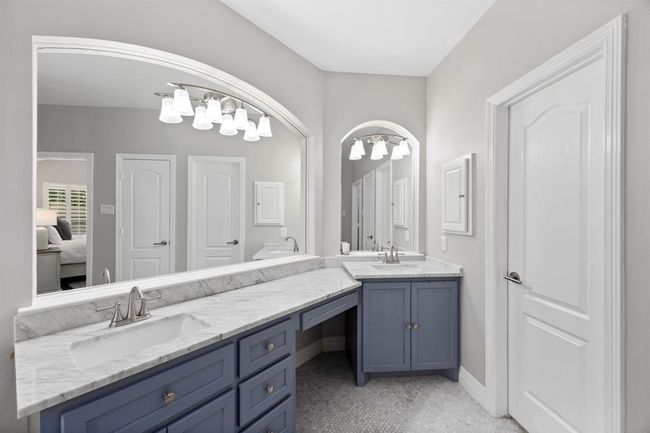 Custom clawfoot tub with vintage-inspired faucet, marble mosaic floors, marble subway tile, seamless glass shower, and marble-topped vanities. | Image 28