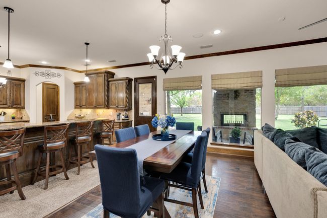 Dining space featuring dark wood finished floors, a chandelier and plenty of natural light | Image 9