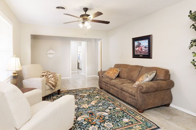 Living room featuring visible vents, baseboards, ceiling fan, and light tile patterned floors | Image 7