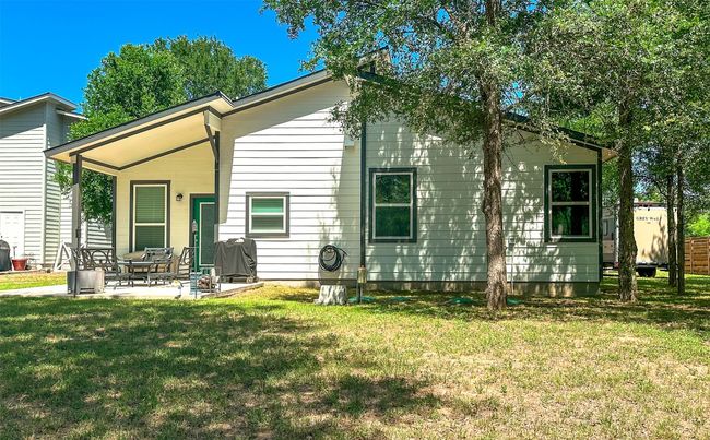 Tree-shaded backyard view of the house. | Image 8