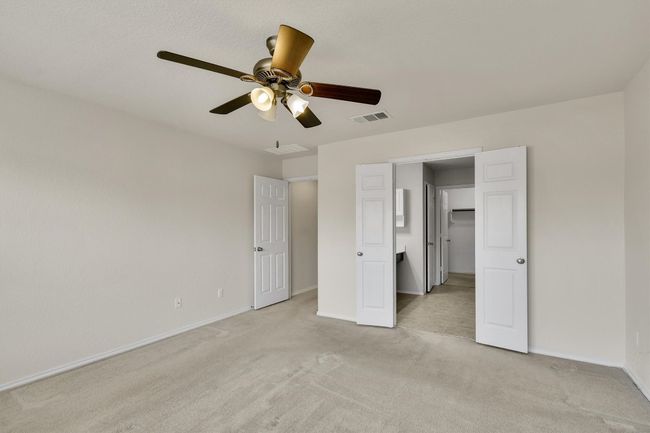 Unfurnished bedroom with light carpet, baseboards, visible vents, and ceiling fan | Image 23