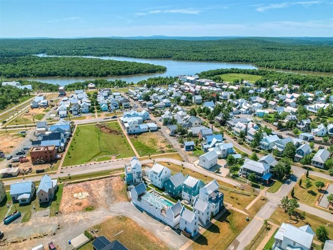 Aerial perspective of suburban area with a large body of water and a forest | Image 49