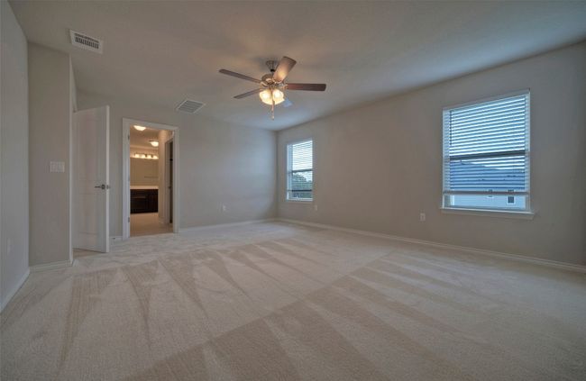 Spare room featuring light carpet, baseboards, visible vents, and a ceiling fan | Image 18