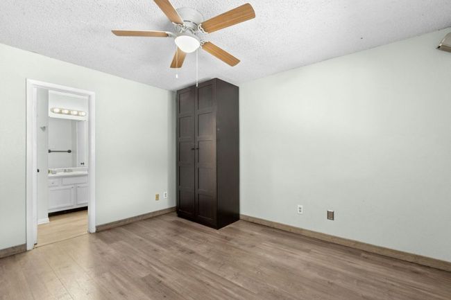 Unfurnished bedroom featuring light wood-type flooring, a ceiling fan, a textured ceiling, and connected bathroom | Image 26