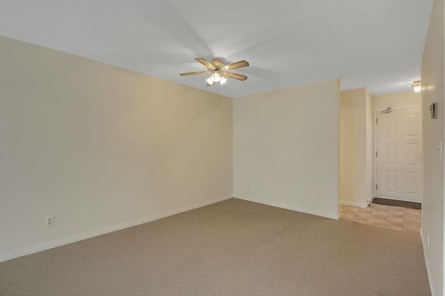 Unfurnished room with a ceiling fan and light colored carpet | Image 9