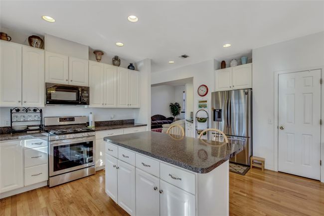 Kitchen featuring white cabinetry, a center island, and appliances with stainless steel finishes | Image 10