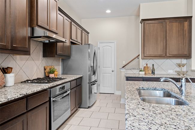 Stair case tucked through the kitchen by coffee bar and large pantry! | Image 7