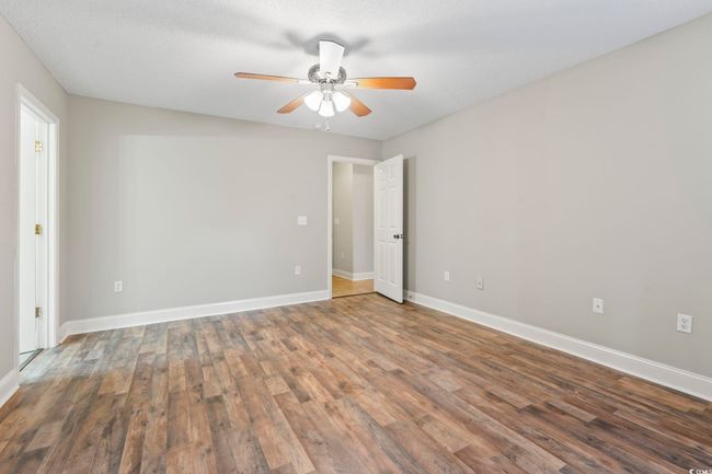 Unfurnished room with wood finished floors, a ceiling fan, and baseboards | Image 19