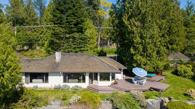 Rear view of property with a wooden deck, a lawn, and a chimney | Image 4