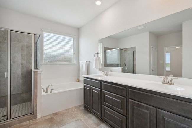 Bathroom featuring a garden tub, a shower stall, and double vanity | Image 18