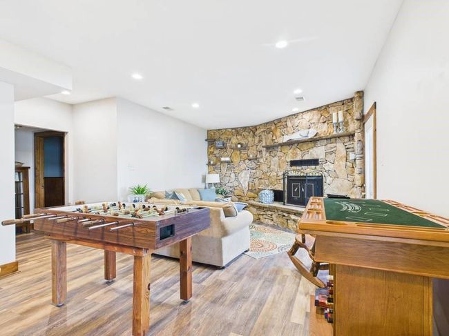 Lower family room featuring recessed lighting, wood floors, and a fireplace | Image 48
