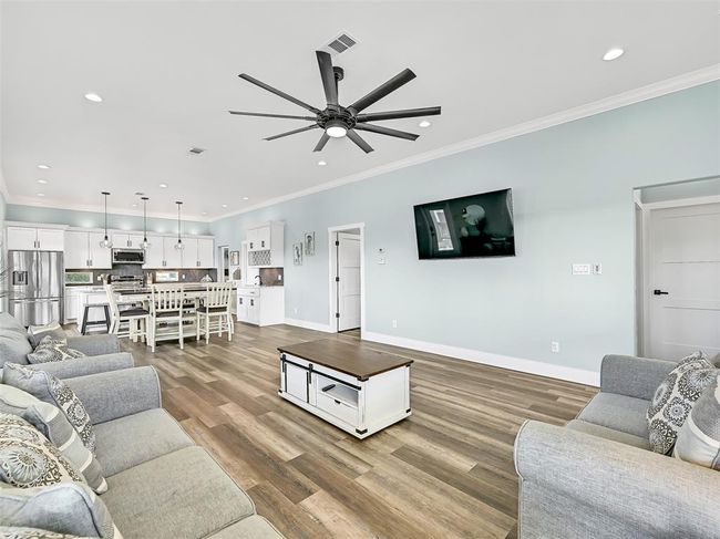 Note the energy-efficient double-paned windows and spray foam insulation that keep this home comfortable year-round, as well as the seamless transition from the spacious living area to the ample dining space, wet bar, and island kitchen. | Image 9