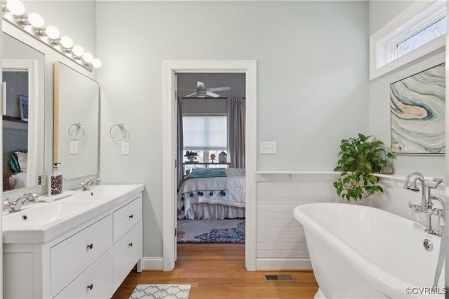 Ensuite bathroom featuring a sink, wood finished floors, visible vents, and connected bathroom | Image 23