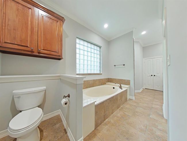 Primary downstairs bath with a luxurious soaking tub for ultimate relaxation. | Image 20