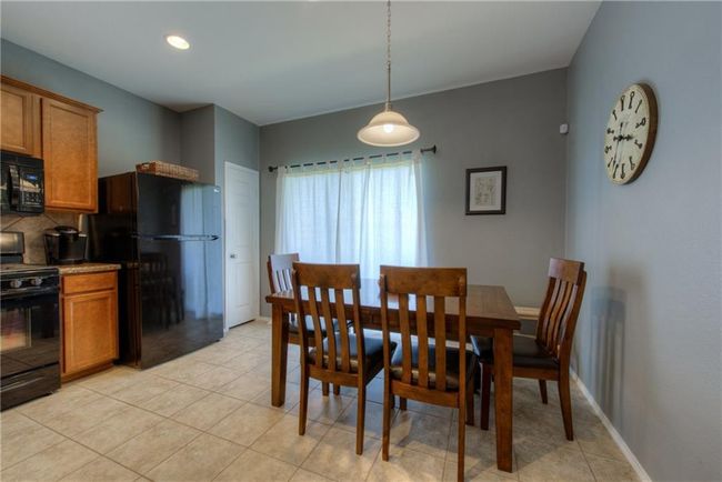 Dining area featuring light tile patterned floors and baseboards | Image 6