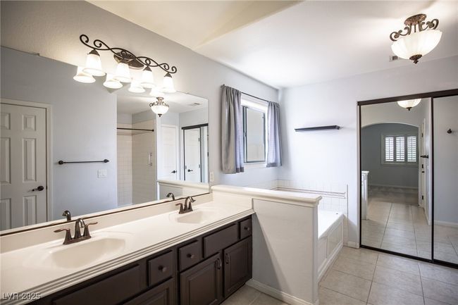 Bathroom with a garden tub, tile patterned flooring, double vanity, and a sink | Image 20