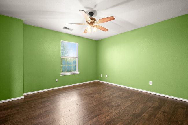 Primary bedroom perfect for rest and relaxation with wood finished floors, ceiling fan, ensuite and large walk-in closet | Image 15