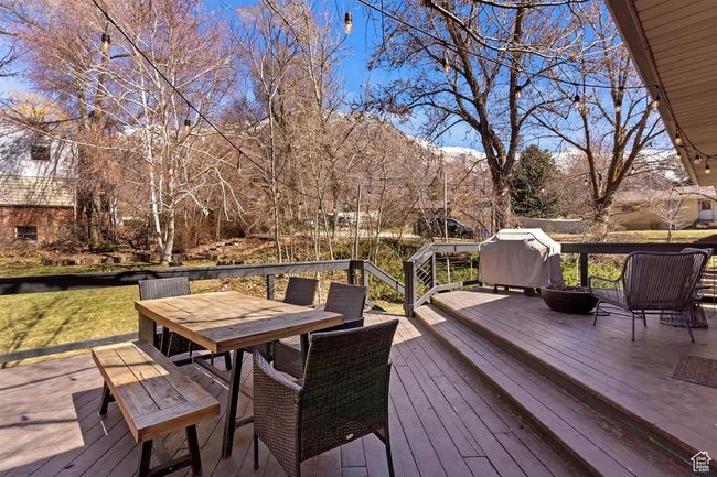 Deck with outdoor dining space, a mountain view, and grilling area | Image 32