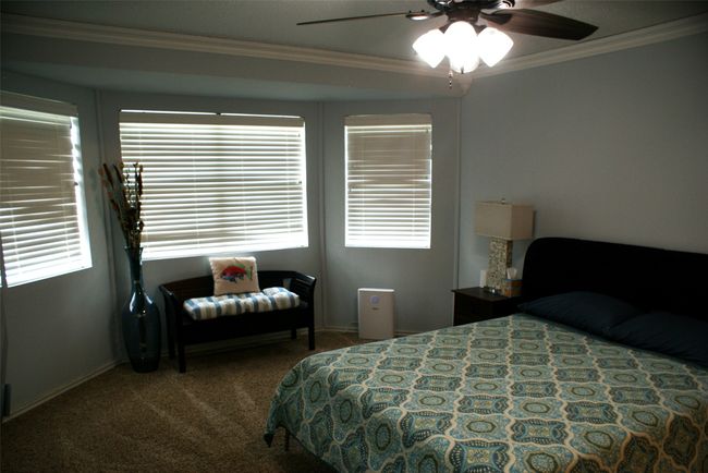 Carpeted bedroom with ornamental molding, multiple windows, and a ceiling fan | Image 18