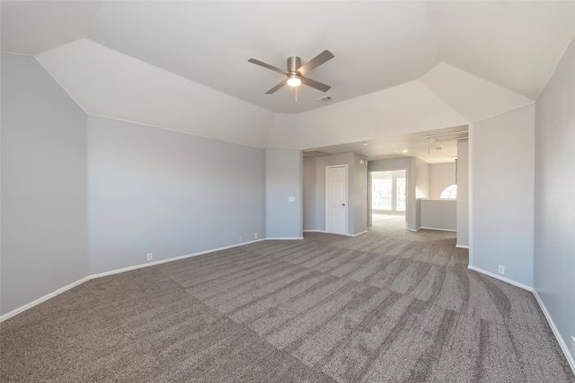 Carpeted empty room with lofted ceiling, attic access, visible vents, and baseboards | Image 30