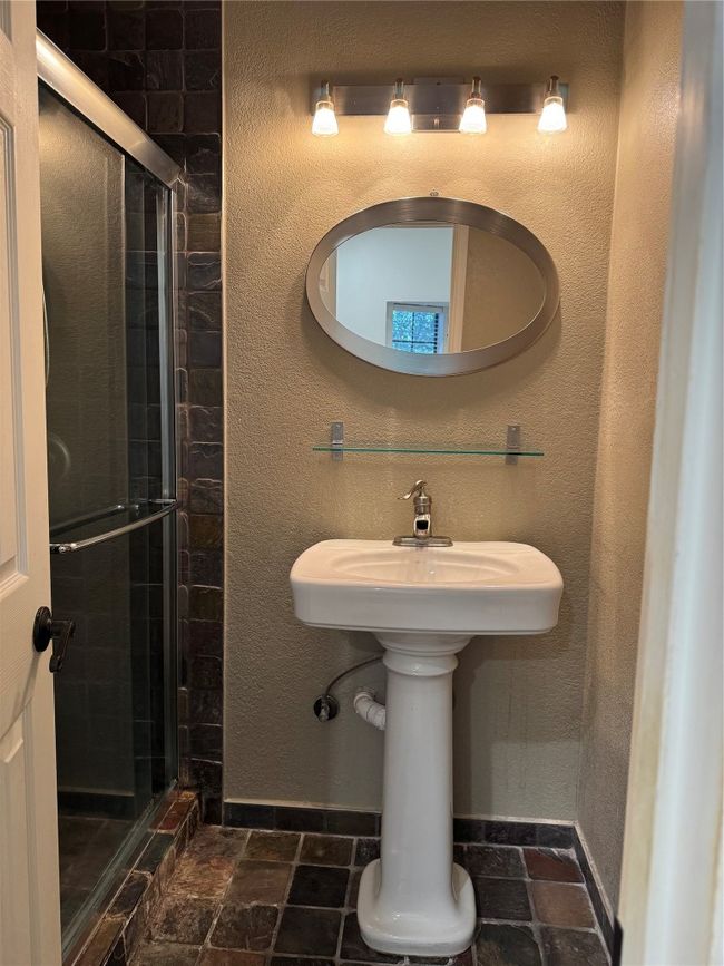Bathroom with a stall shower and stone tile flooring | Image 9