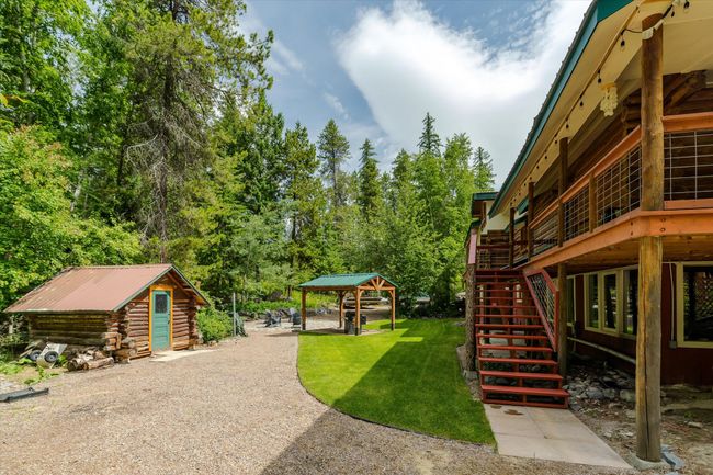 View of green lawn with an outbuilding, stairway, and a wooden deck | Image 13