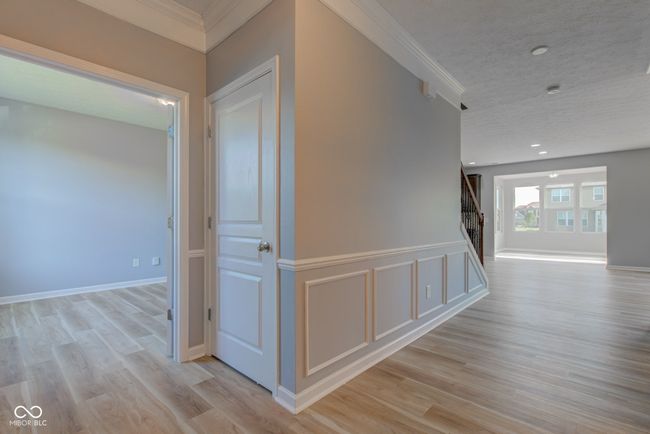 hall featuring crown molding, stairs, light wood-style floors, and recessed lighting | Image 15