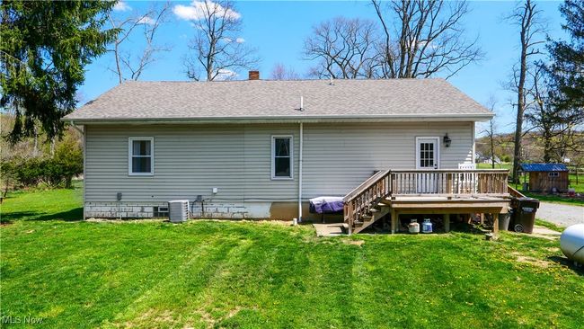 Back of house with a wooden deck, central air condition unit, a shingled roof, a lawn, and a chimney | Image 27